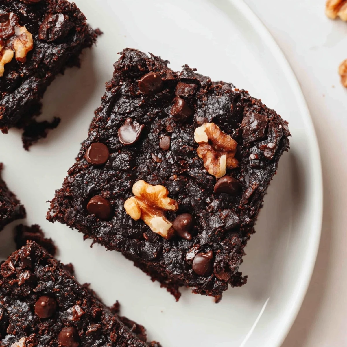 A square of decadent gluten-free almond flour brownie, offering a glimpse of the chocolatey goodness within.