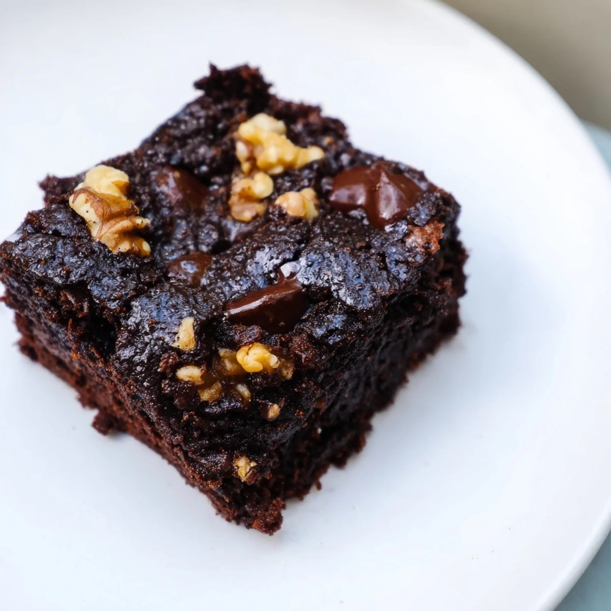 Warm gluten-free almond flour brownies, rich and fudgy, with visible chocolate chips and a tender crumb.