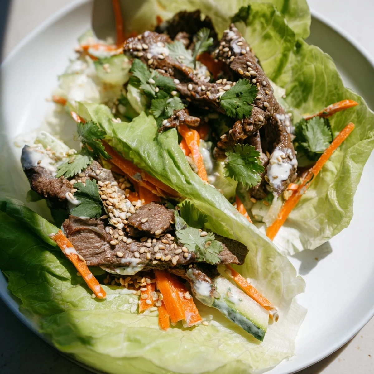 Served on a wooden table, the high-protein Beef Wrap with Lettuce features creamy yogurt sauce and toasted sesame seeds.