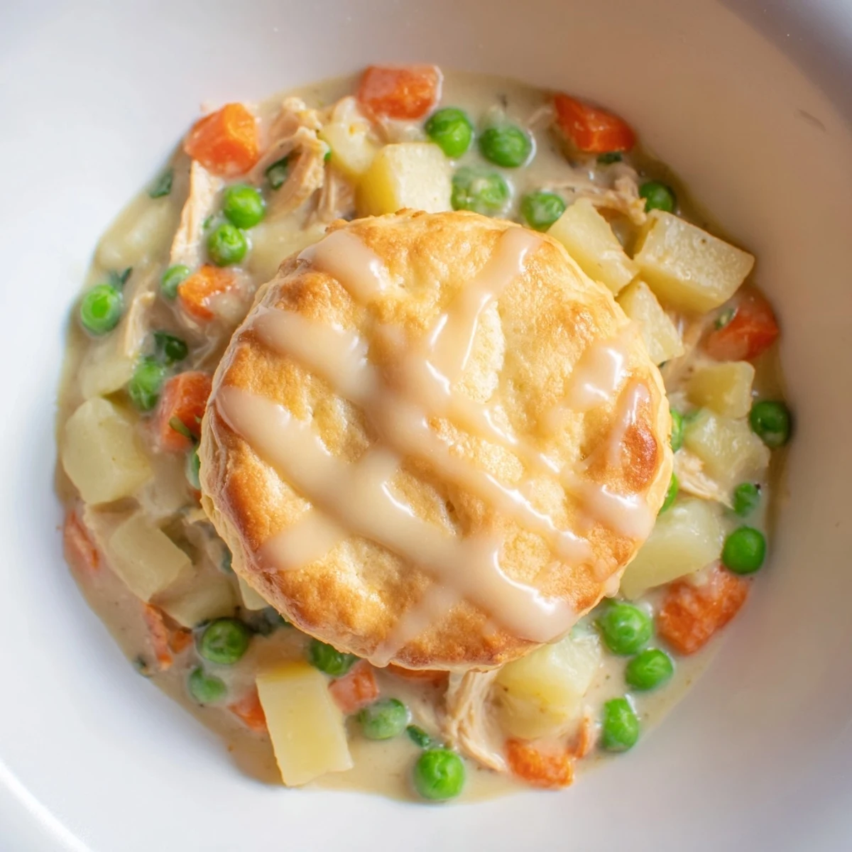 Spoon lifts creamy Chicken Pot Pie Soup from a deep bowl, topped with tender shredded chicken and veggies.