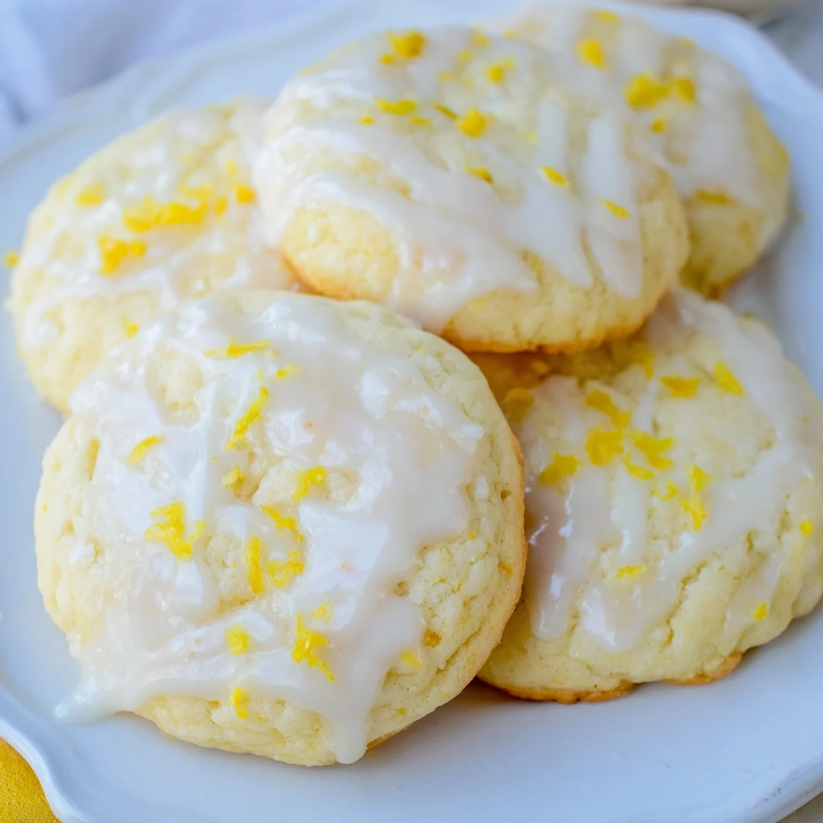 Stack of golden Lemon Ricotta Cookies with sweet lemon glaze, served on a ceramic plate for spring dessert.