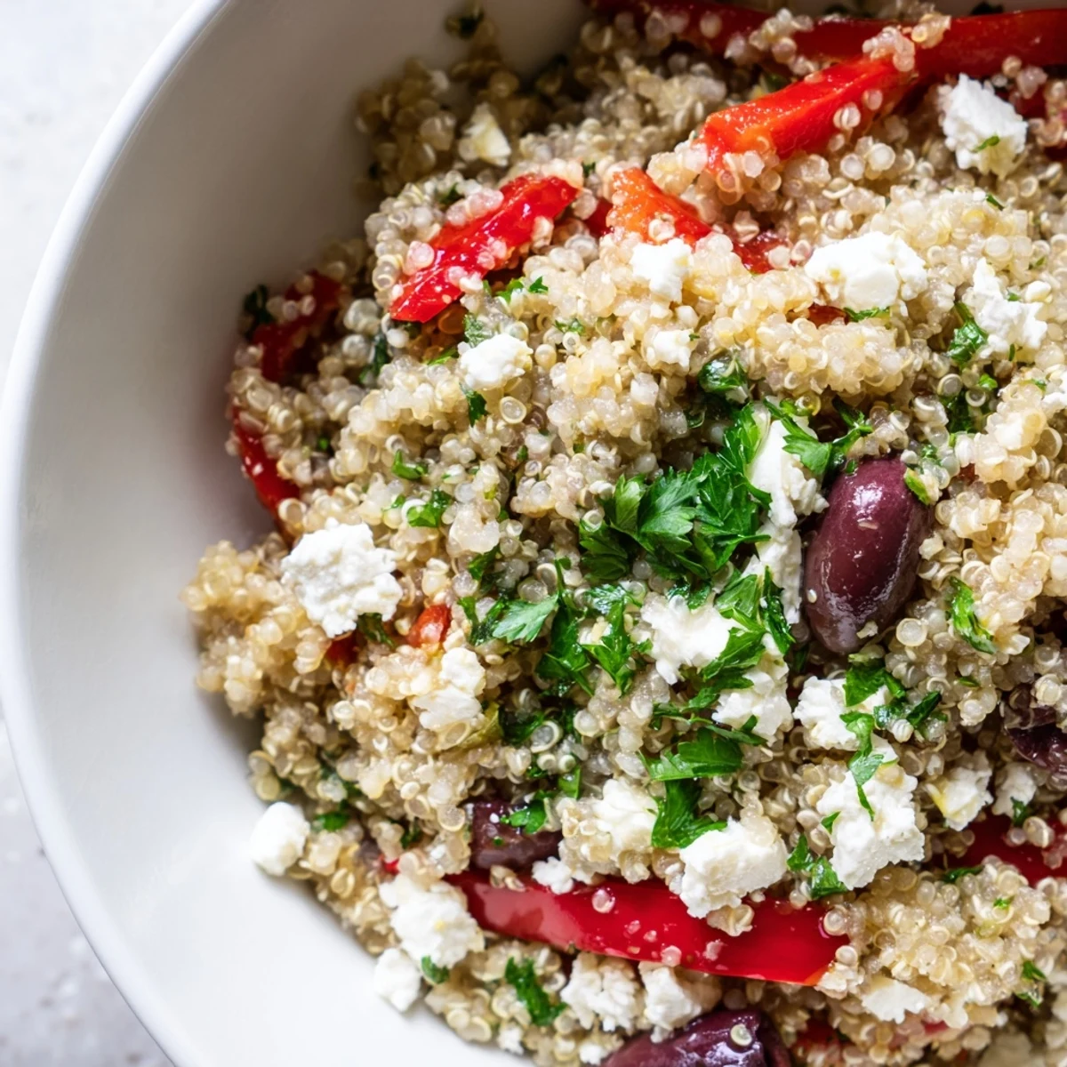 Fluffy Mediterranean Quinoa Salad with tangy feta and briny olives, tossed with fresh lemon dressing.