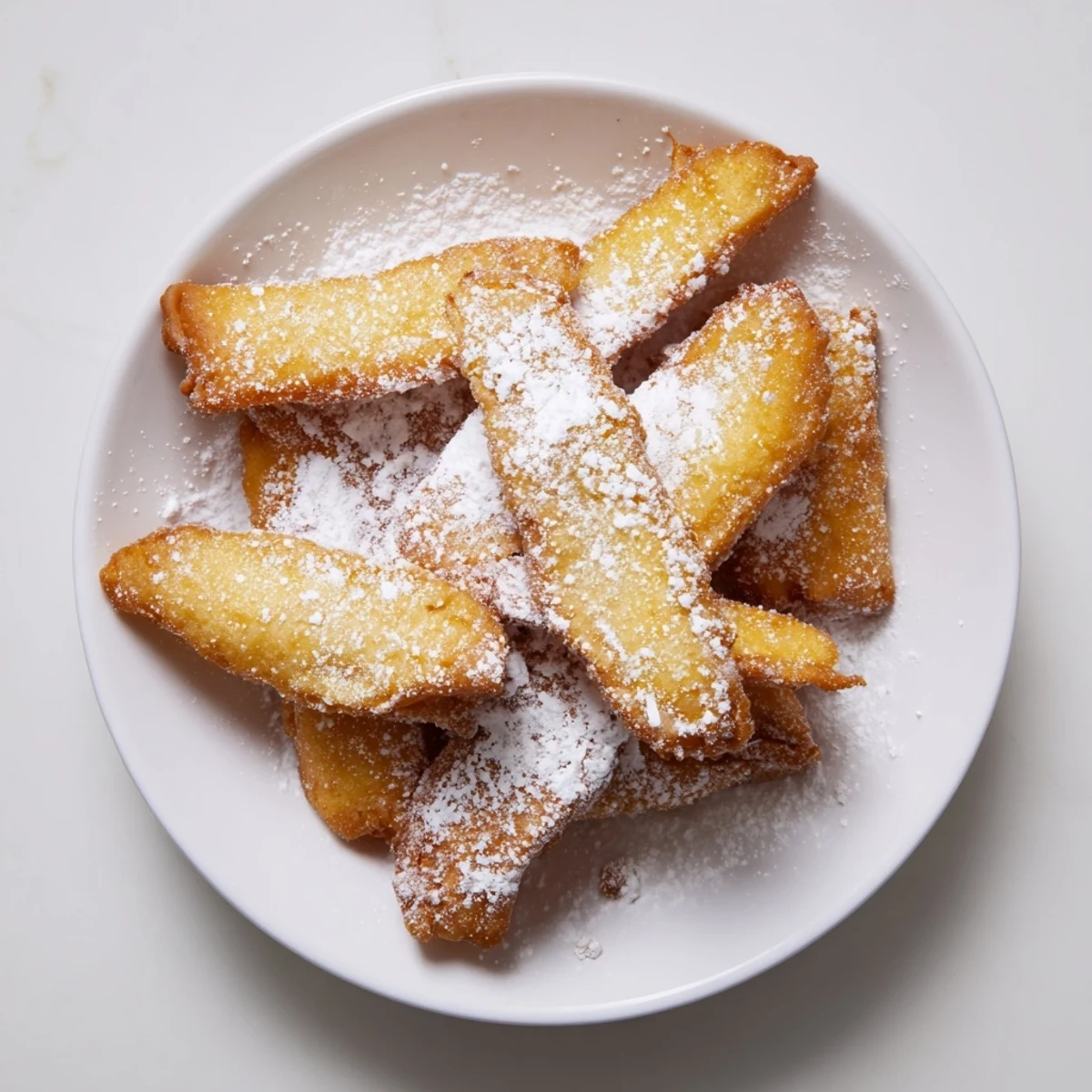 Freshly fried New Orleans Beignet Fries drizzled with chocolate sauce for a sweet brunch treat.