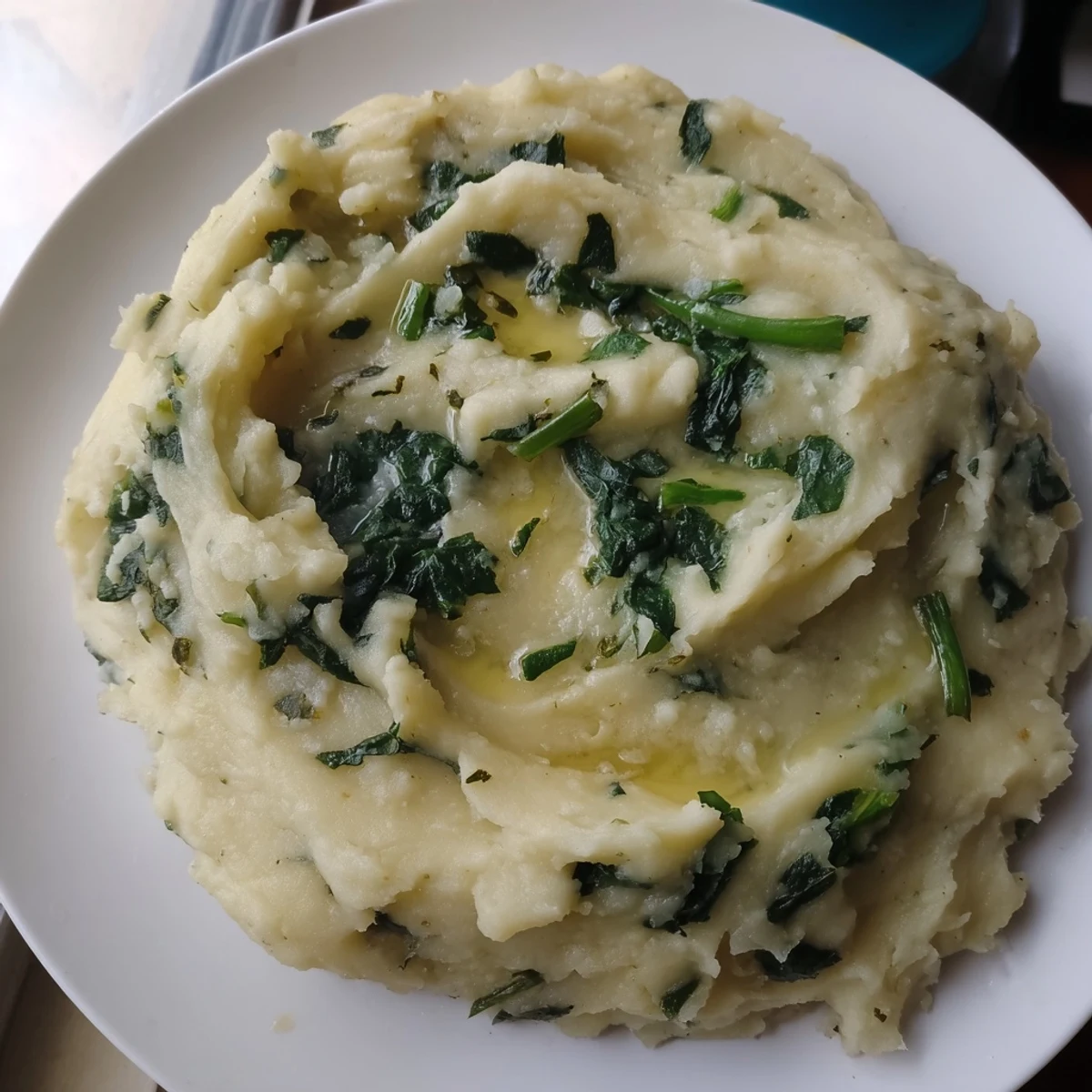 Creamy Irish Colcannon Mashed Potatoes with Kale in a rustic bowl, topped with melting butter and fresh scallions.