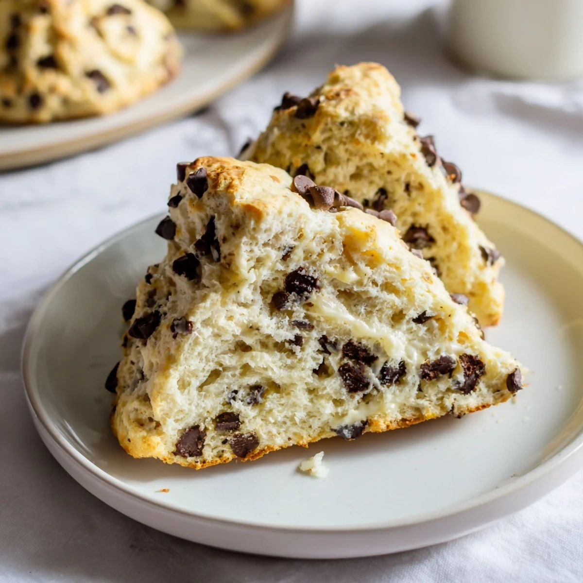 Freshly baked Chocolate Chip Scones resting on a rustic wooden table, ready for an indulgent breakfast treat.
