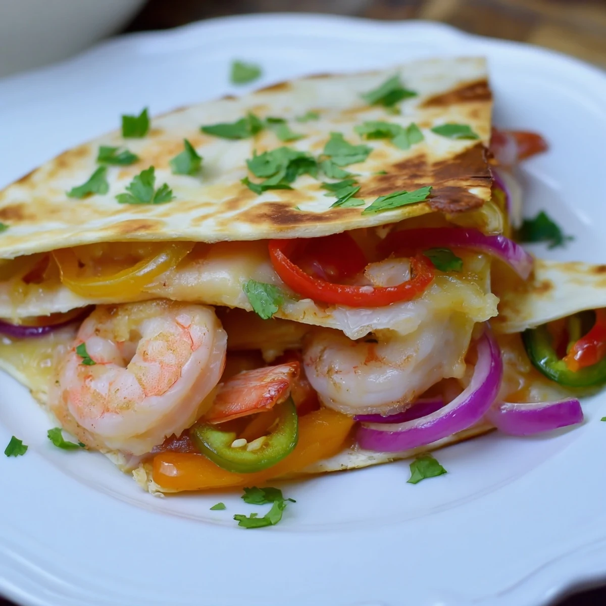 Golden-brown Shrimp Fajita Sheet Pan Quesadillas are cut into wedges, revealing a filling of juicy shrimp, roasted peppers, and melty cheese.