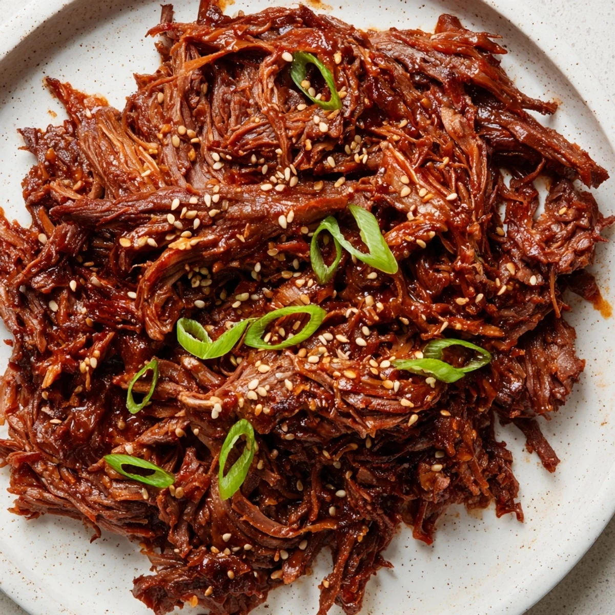 Savory Crock Pot Korean Beef chunks shredded and coated in thick sauce, served over steaming jasmine rice.