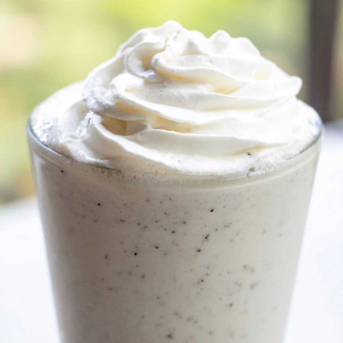 A creamy Starbucks Vanilla Bean Frappuccino topped with whipped cream in a tall glass, frosty and refreshing.