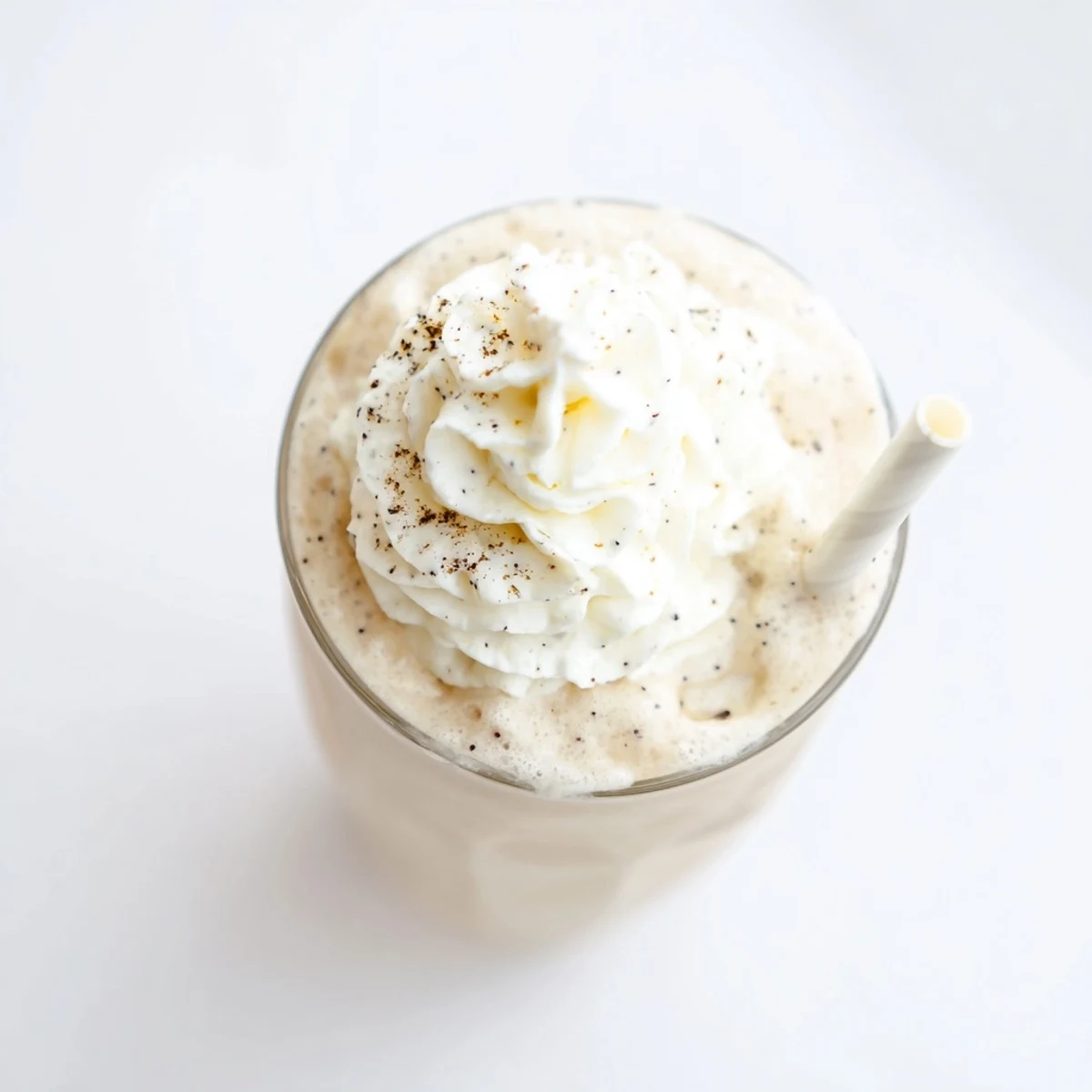 Close-up of a Vanilla Bean Frappuccino with smooth texture and vanilla seeds, garnished with whipped cream.