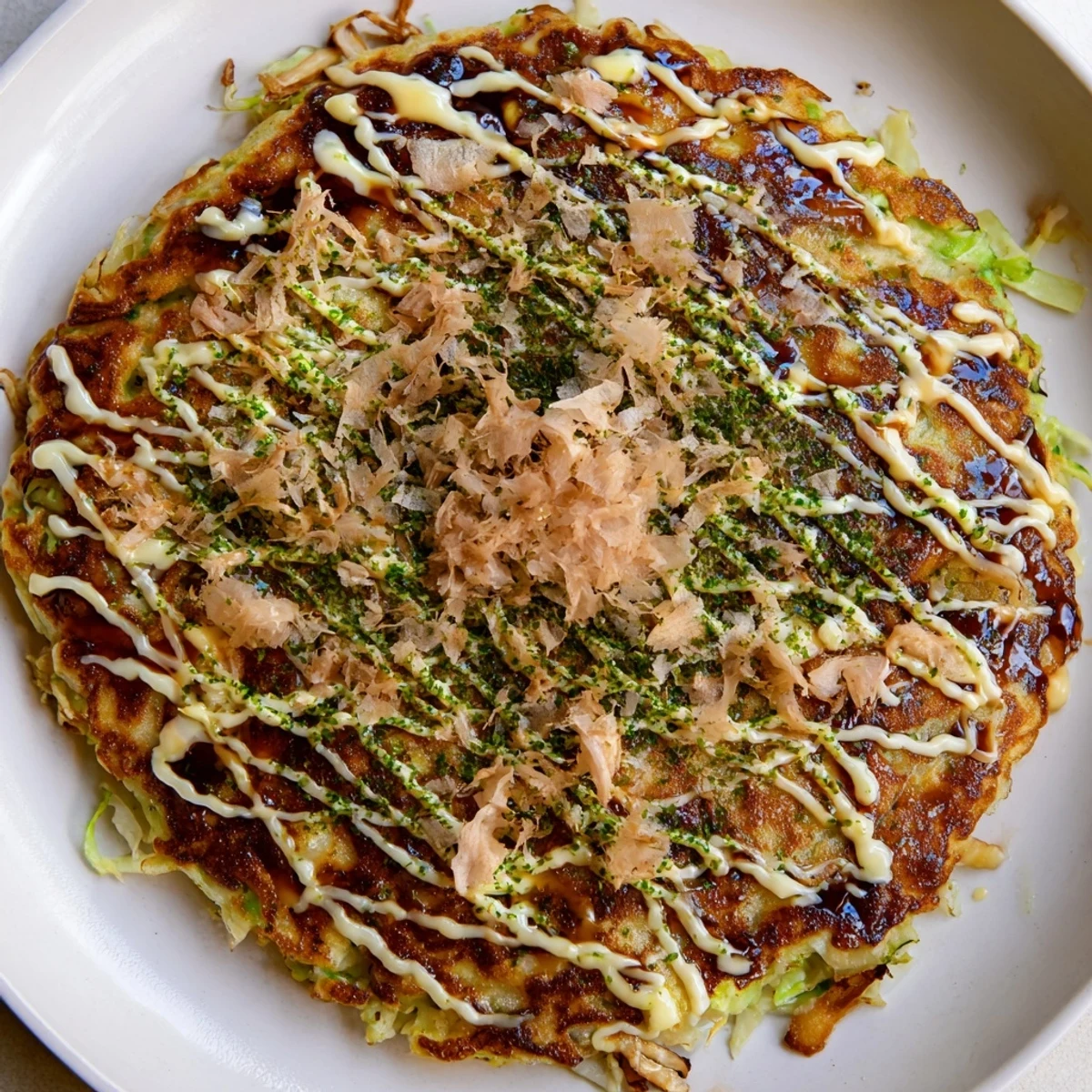A close-up of a sliced Chicken Okonomiyaki revealing tender chicken pieces and shredded cabbage inside a fluffy Japanese-style pancake.