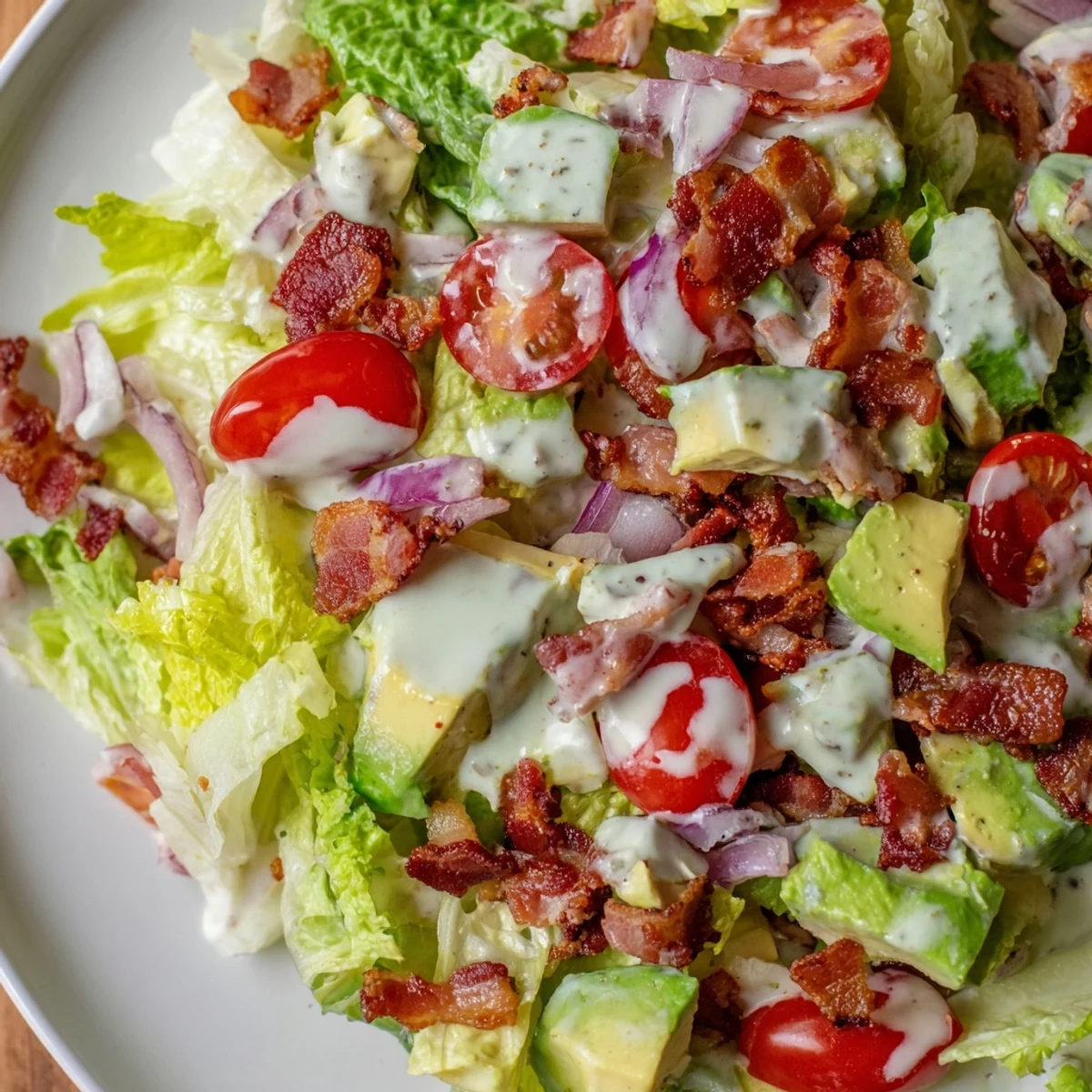 Serving suggestion for Crispy Bacon Keto BLT Salad, garnished with chives on a bright table.