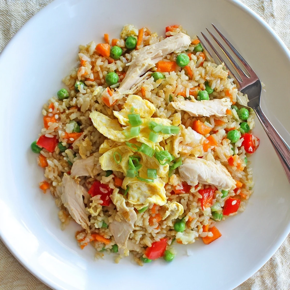 Golden chicken fried rice with colorful vegetables and delicate egg omelette strips on top