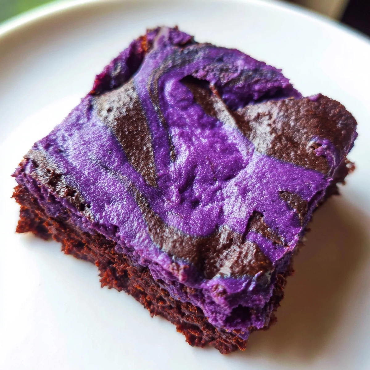 Fudgy ube brownies swirled with melted chocolate on a white plate