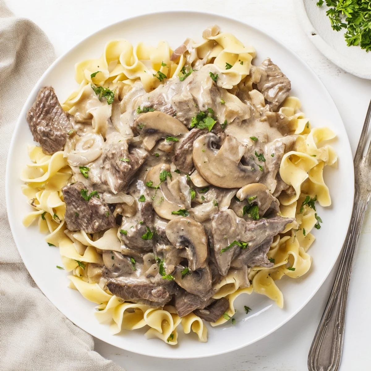 Tender beef strips and earthy mushrooms simmered in rich sour cream sauce over noodles