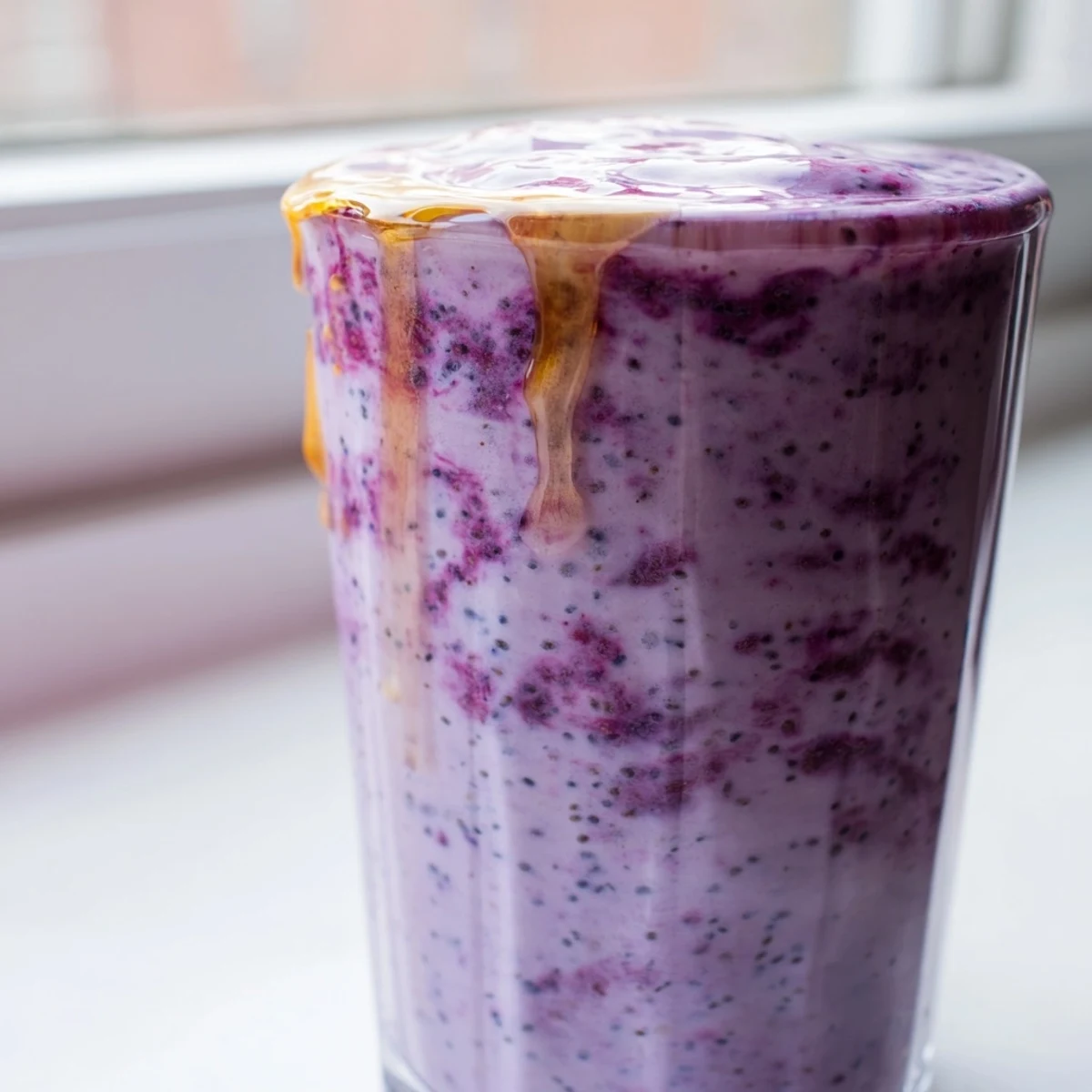 Creamy Greek yogurt breakfast smoothie blended with banana and mixed berries on wooden table