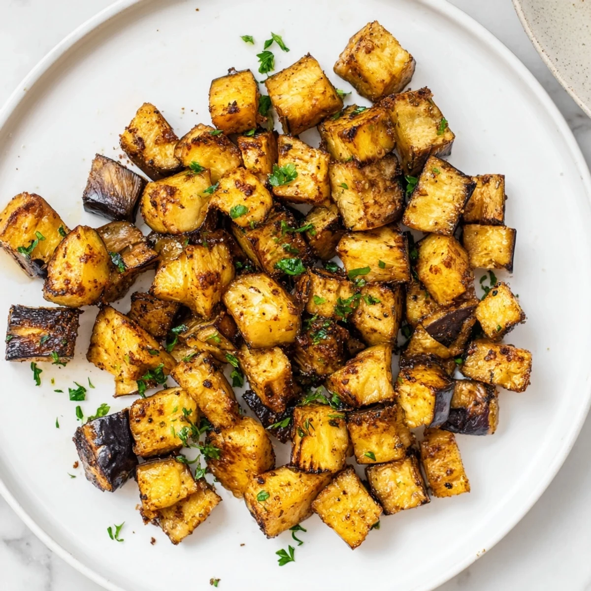 Crispy Mediterranean style low calorie air fryer eggplant pieces showing golden edges and tender interior texture