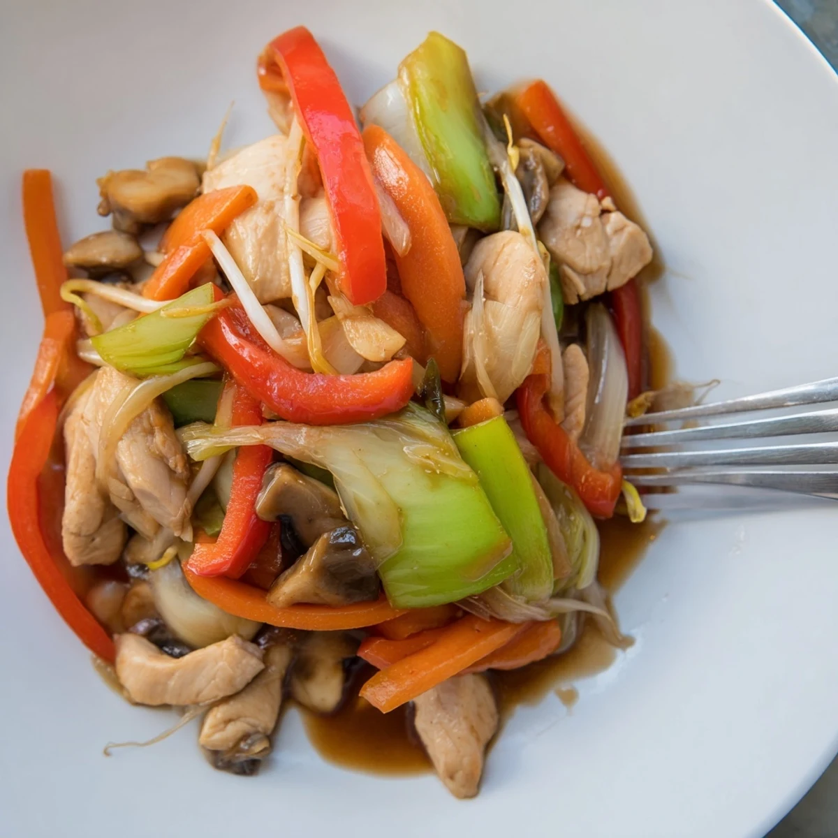 Vibrant Chinese-American Chop Suey featuring sliced pork, bell peppers, bean sprouts, and cabbage in a rich thickened brown sauce