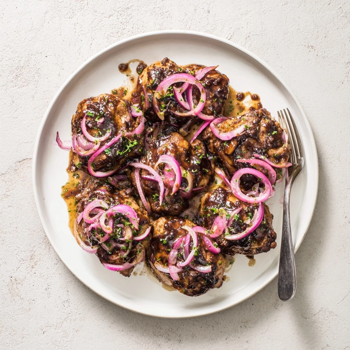 Tender chicken thighs coated in rich balsamic honey sauce served in a white ceramic slow cooker