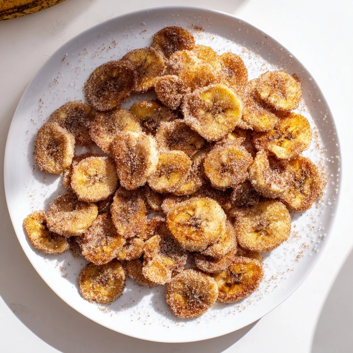 Golden cinnamon sugar air fryer banana chips arranged on a wire rack after cooling