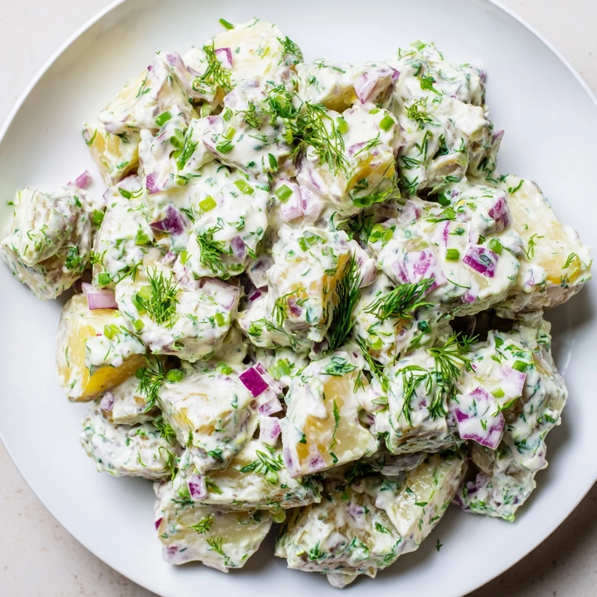 Creamy Greek yogurt potato salad with tender red potatoes, fresh herbs, and crisp diced vegetables in a light tangy dressing