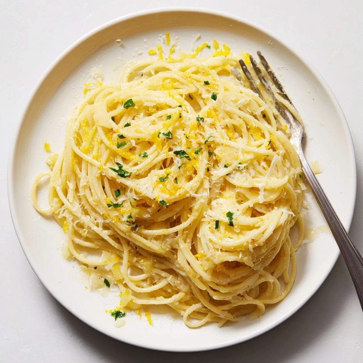 Golden garlic butter pasta coated in rich savory sauce with fresh parsley and Parmesan