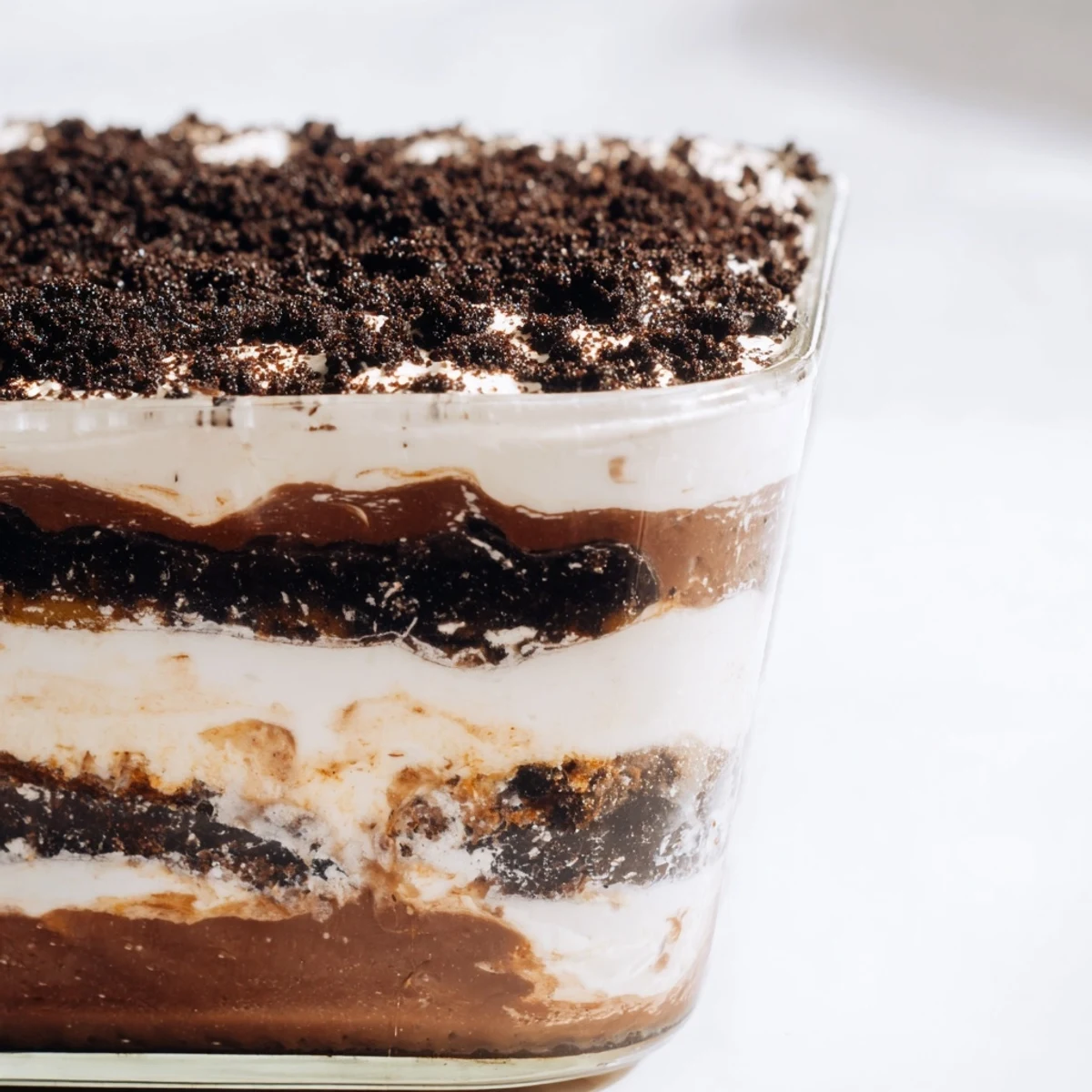 Close-up of low-carb dirt cake topped with crunchy chocolate almond dirt in clear glass