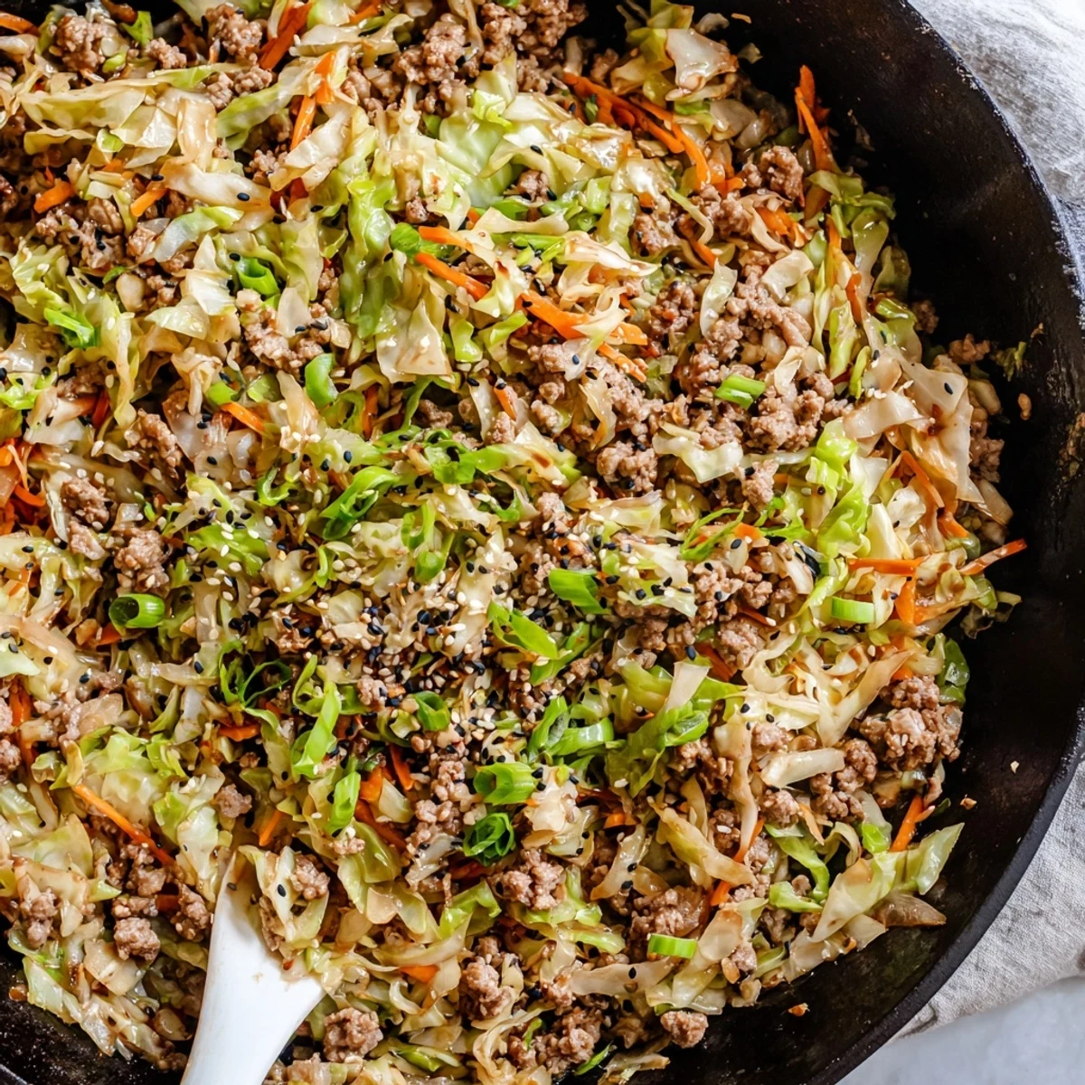Sizzling one-pan egg roll in a bowl with tender vegetables and sesame seed garnish