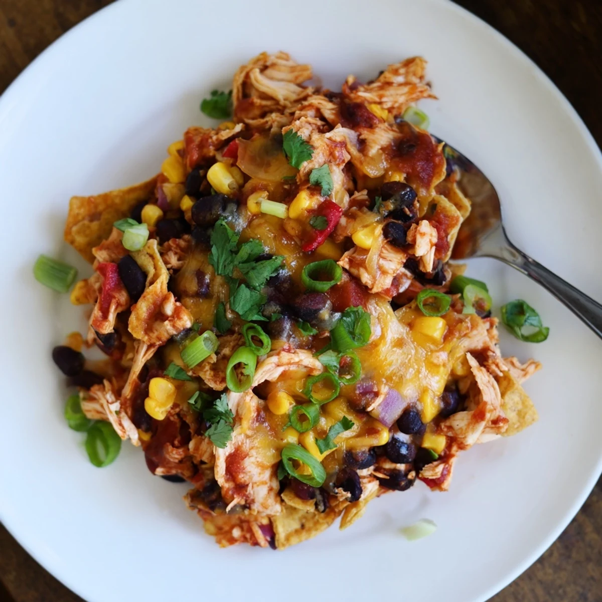 Layered Tex-Mex chicken enchilada casserole bubbling with sauce and shredded Mexican cheese blend