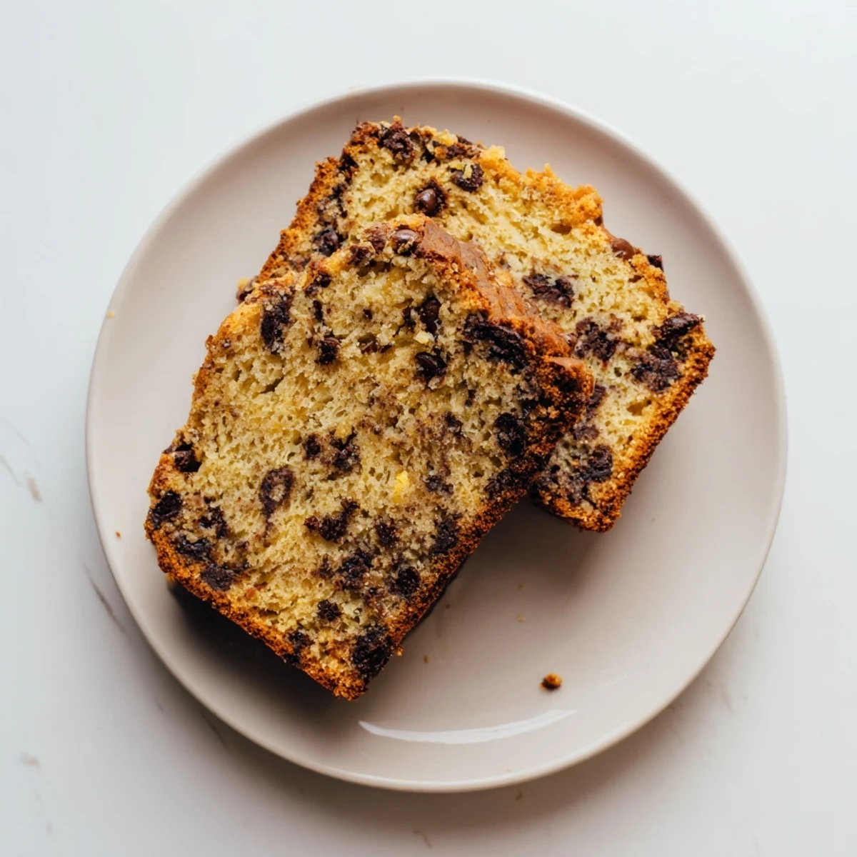 Freshly baked chocolate chip banana bread loaf cooling on a wire rack with parchment