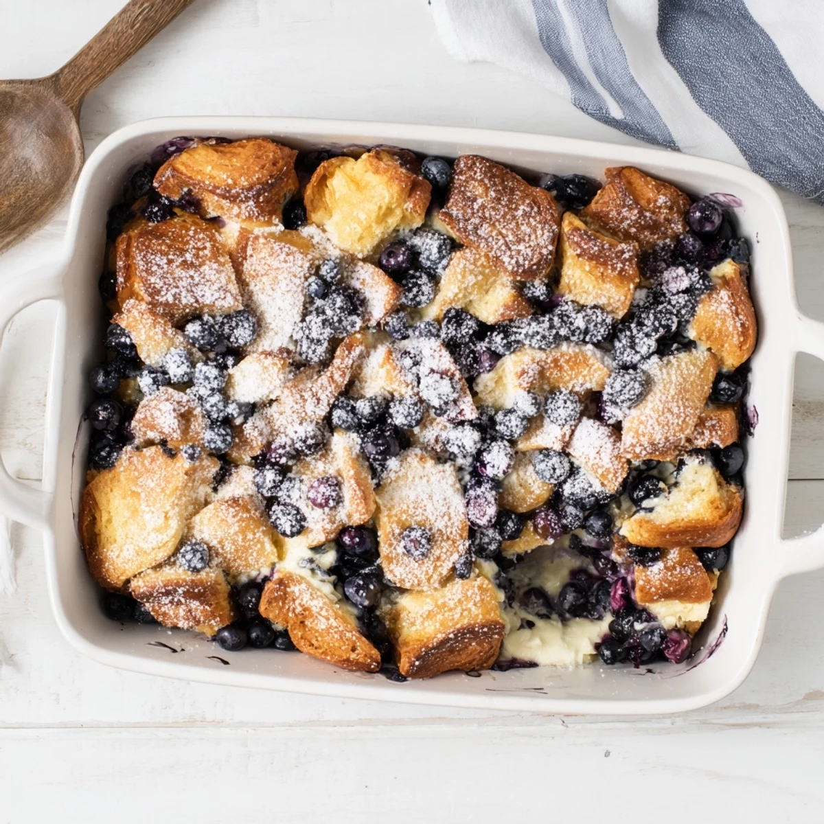 Golden blueberry cream cheese croissant casserole with buttery pastry layers and sweet custard