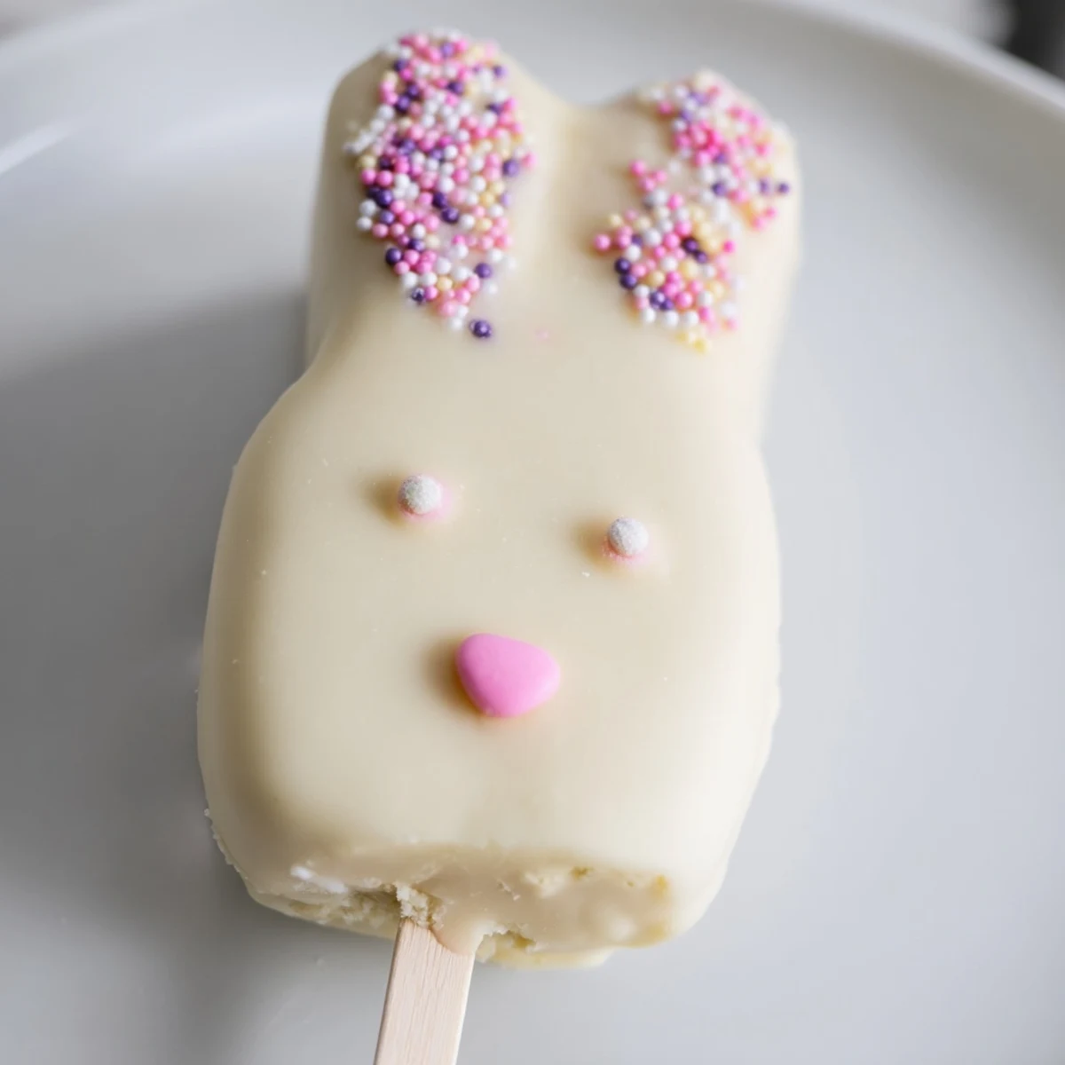 Creamy white chocolate bunny cakesicles decorated with sprinkles for festive Easter celebrations
