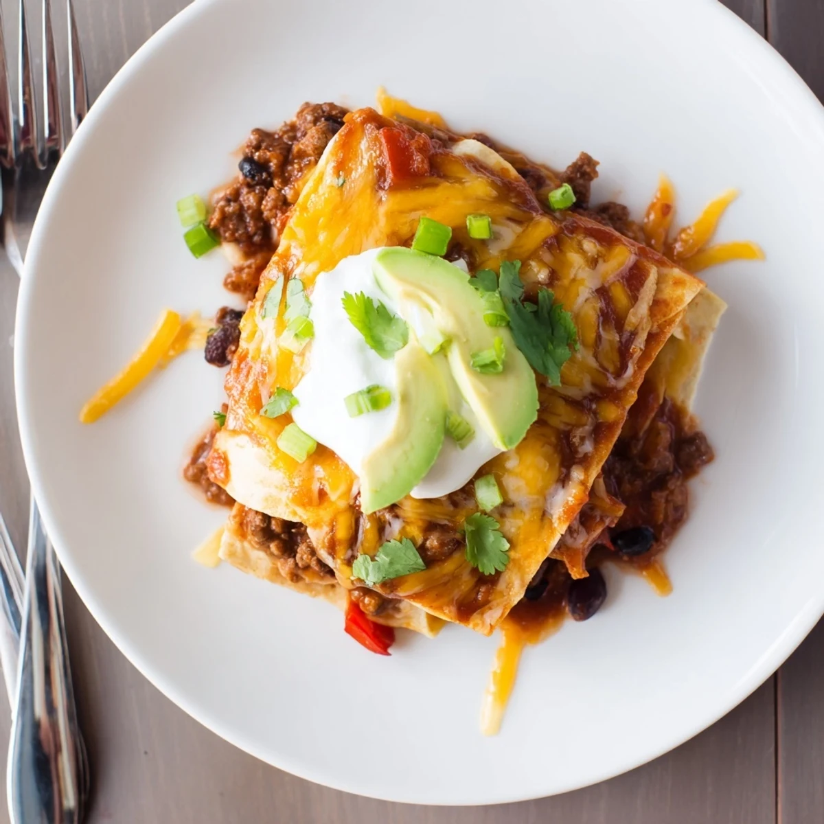 Hearty Beef Skillet Enchiladas layered with corn tortillas, black beans, warm sauce