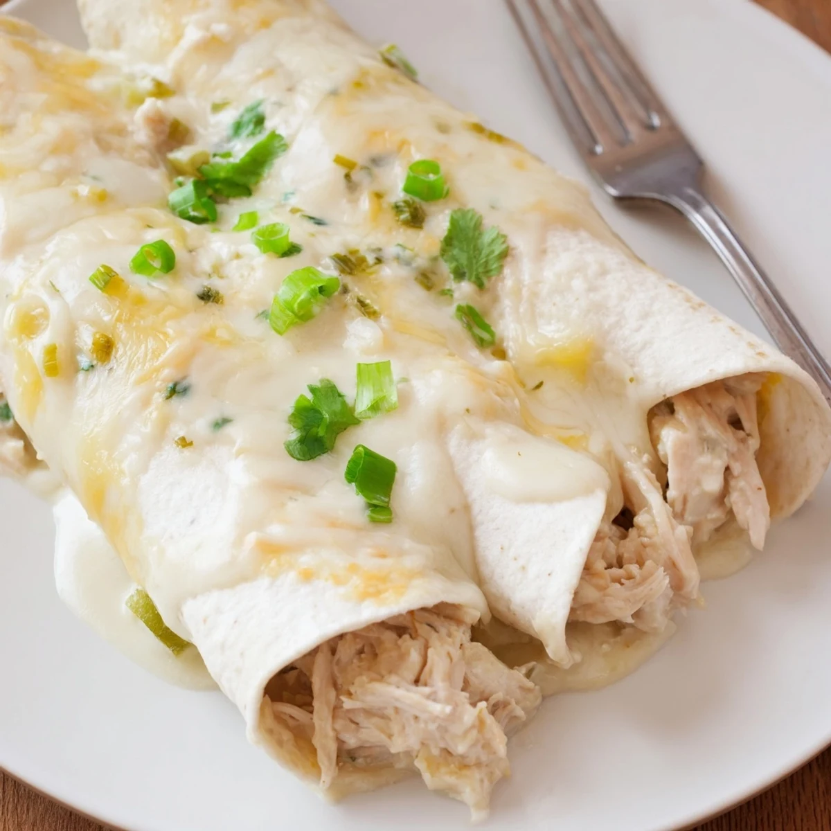 Baked Creamy White Chicken Enchiladas on casserole dish, ready for family dinner