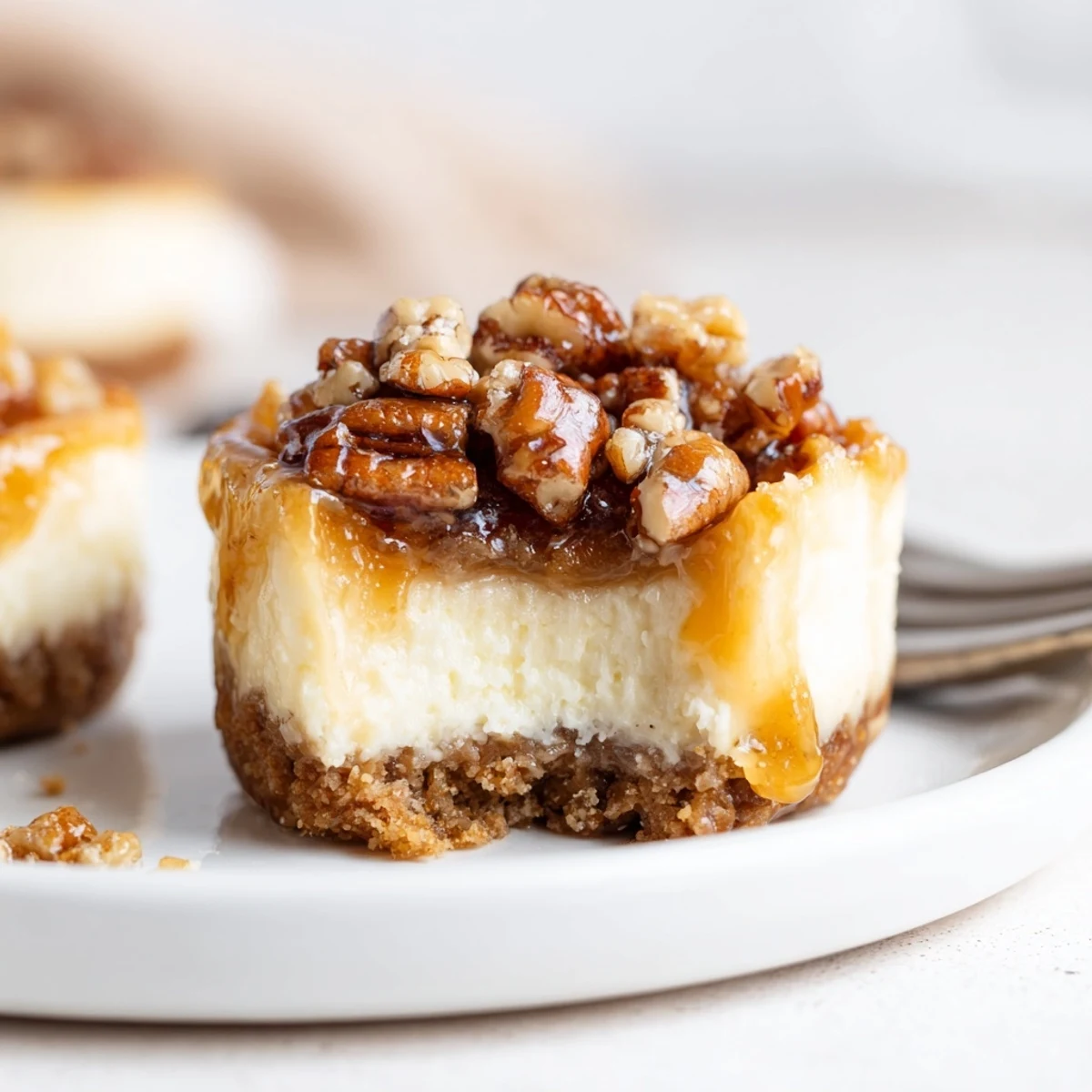 A plate of Mini Pecan Pie Cheesecakes chilled, creamy centers, caramel drizzle