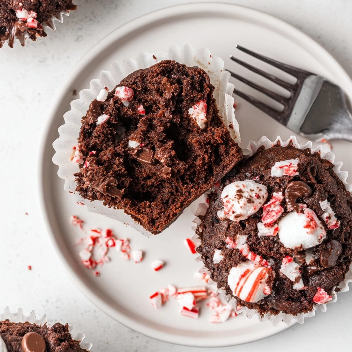Warm Peppermint Hot Chocolate Muffins topped with melted chips and crushed candy