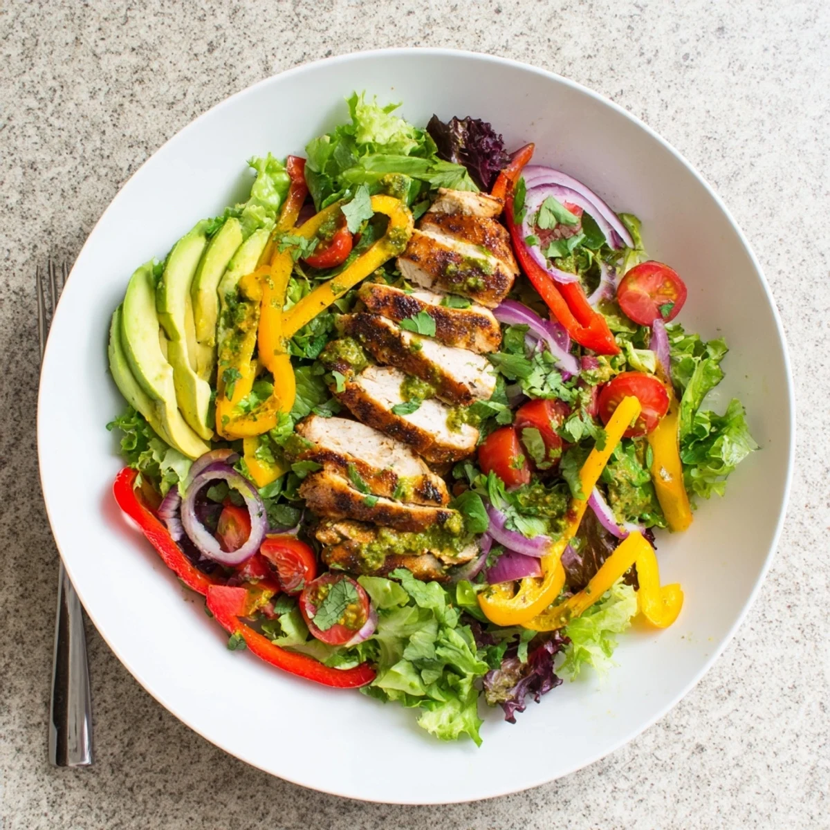 Colorful grilled chicken fajita salad featuring seasoned chicken strips atop mixed greens with bell peppers and avocado