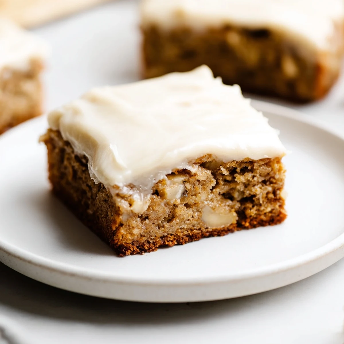 Golden brown banana bread brownies topped with creamy brown butter frosting swirls