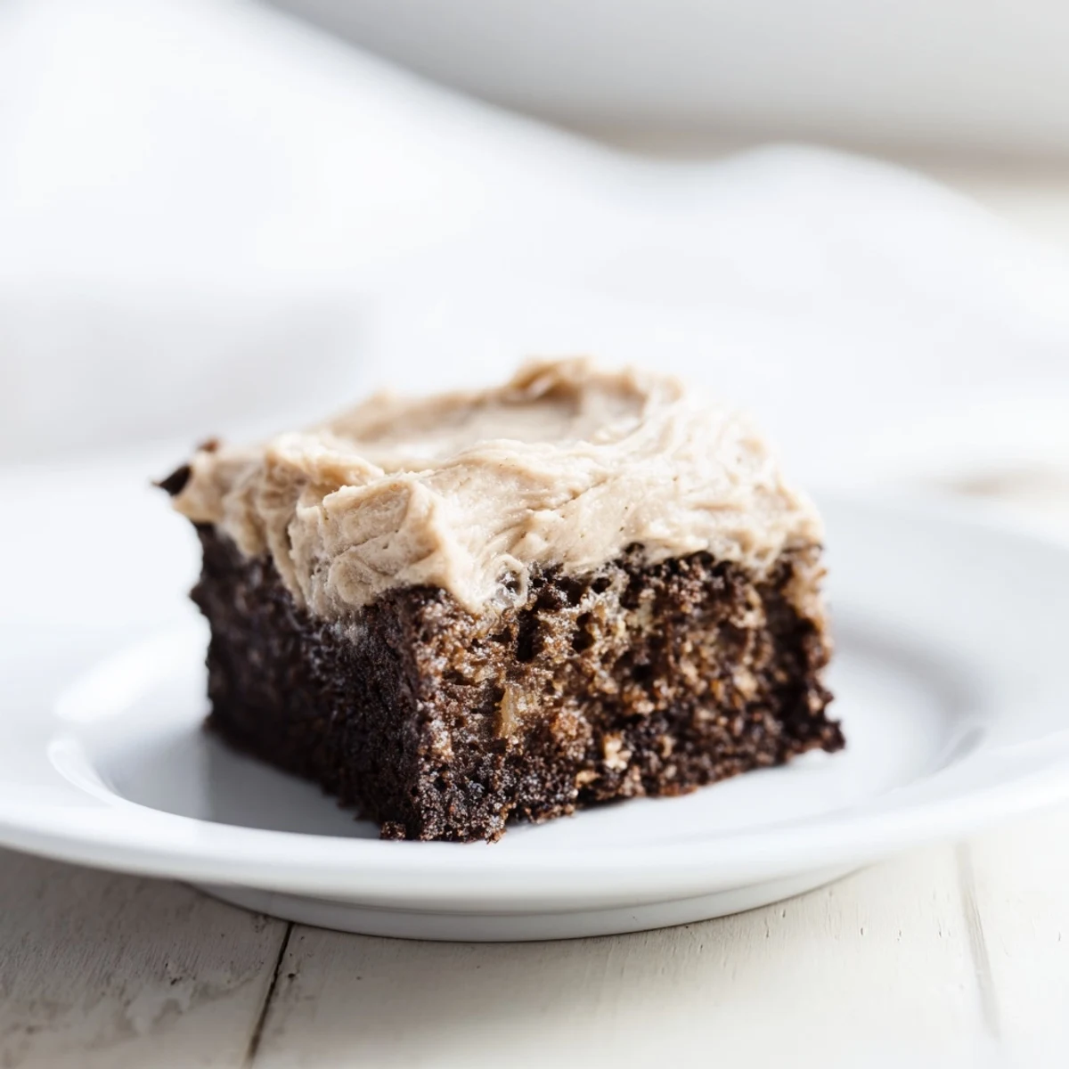 Fudgy banana bread brownies with nutty brown butter frosting on a white plate