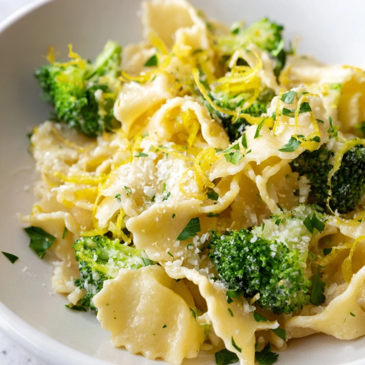 Mafaldine pasta limone broccoli topped with Parmesan and fresh basil garnish