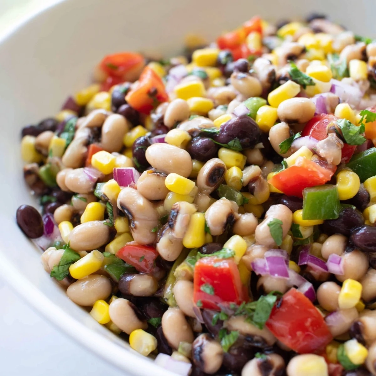 Bright Cowboy Caviar recipe served in a bowl with crispy tortilla chips alongside