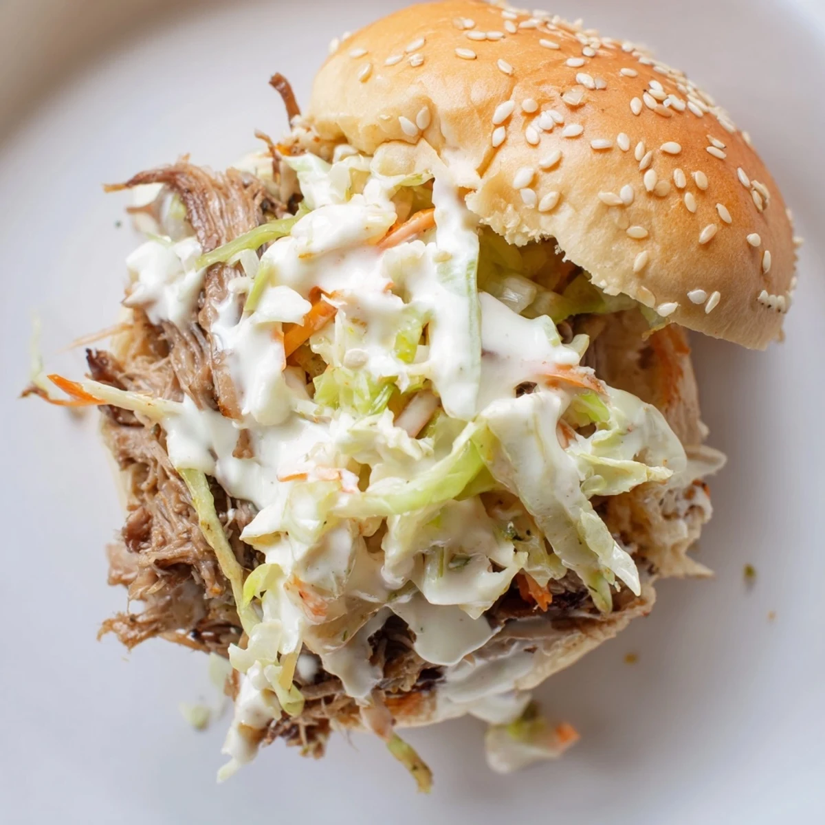 Juicy Alabama white sauce pulled lamb sliders piled high with crunchy creamy coleslaw on toasted buns