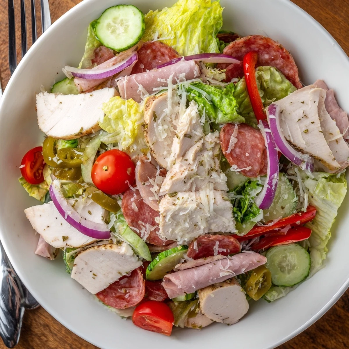 Italian Grinder Chicken Salad layered with crisp romaine, juicy tomatoes, and tangy pepperoncini.