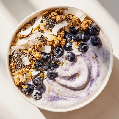 A close-up view of the Lemon Blueberry Smoothie Bowl featuring creamy texture, chia seeds, and a sprinkle of coconut flakes.